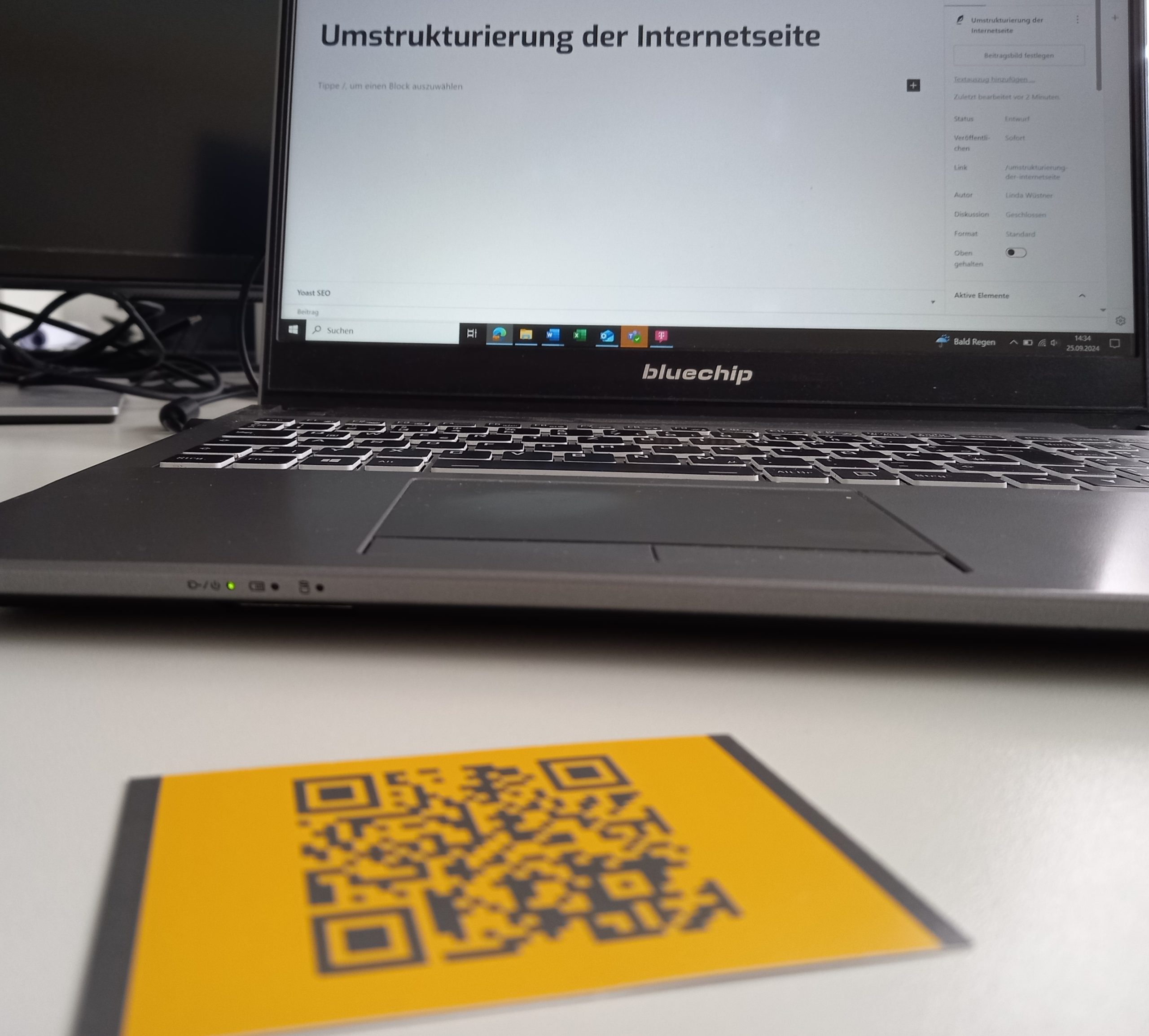 Im Vordergrund ist ein QR-Code zu sehen, der auf die Seite von Unantastbar Mensch führt. Im Hintergrund sieht man die Bearbeitung der Website am Laptop.