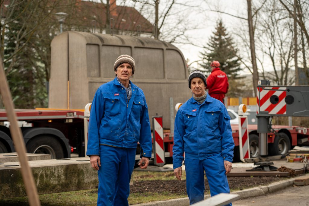 Die Künstler Andreas Knitz und Horst Hoheisel beim Aufbau des Denkmals der grauen Busse.